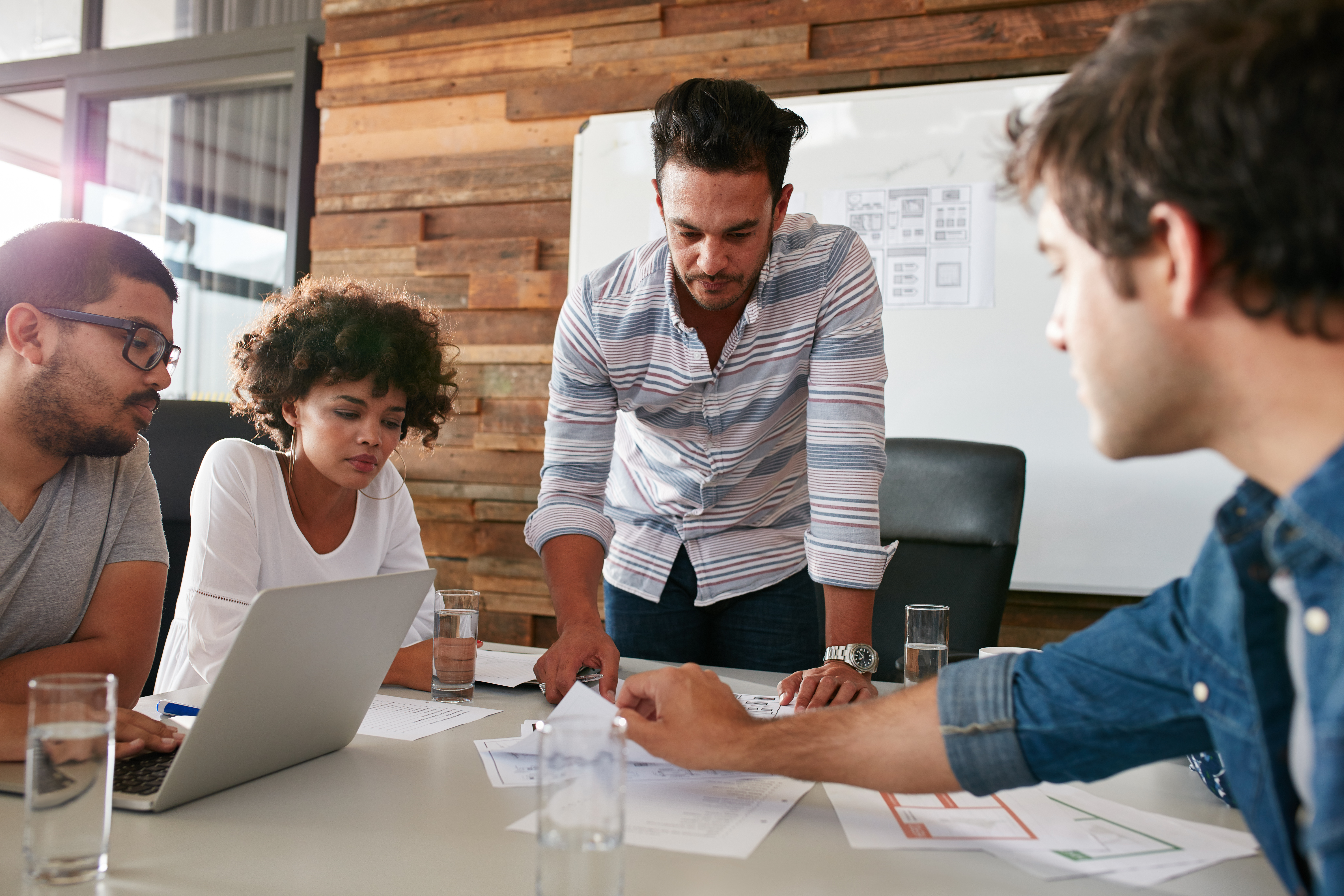Group of 4 people meeting around a conference room table